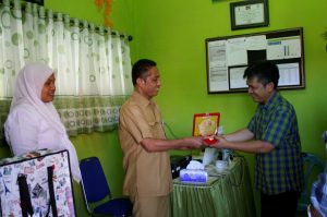 Pak Cipto Leksono (,) menyerahkan Cindera Mata kepada Kepala PKM Dewantara dr. Iskandar